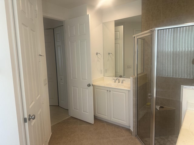 bathroom featuring tile patterned flooring, vanity, and a shower stall