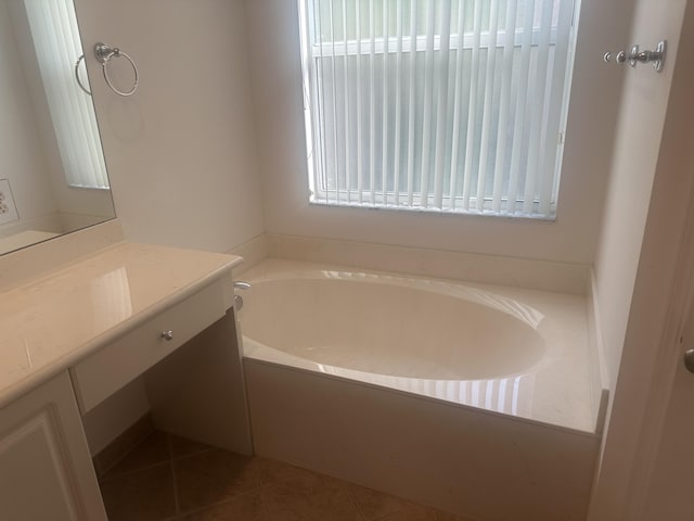 full bath featuring a garden tub, vanity, and tile patterned floors