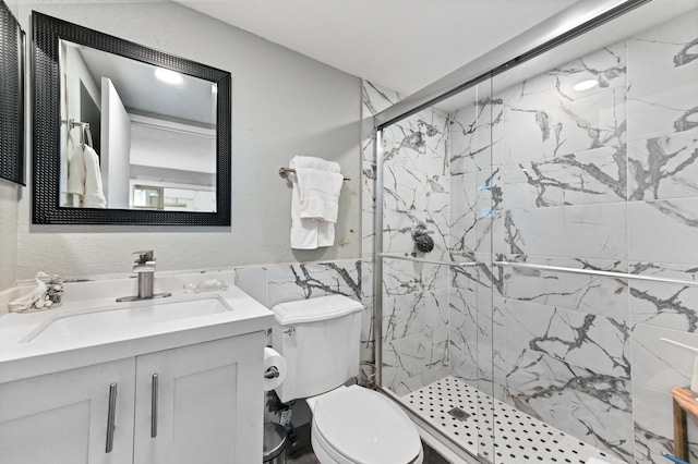 bathroom featuring vanity, toilet, and a shower with shower door