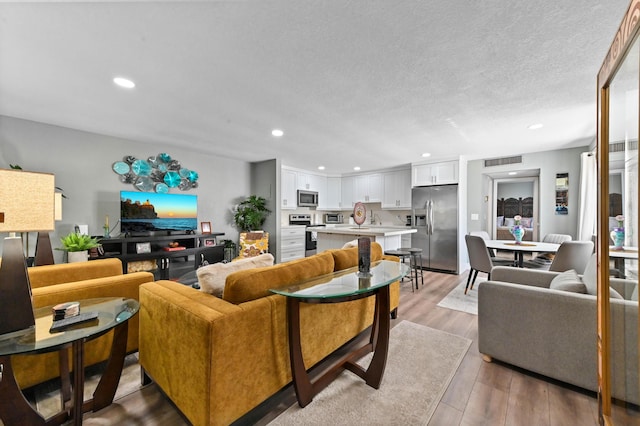 living room with light hardwood / wood-style flooring and a textured ceiling