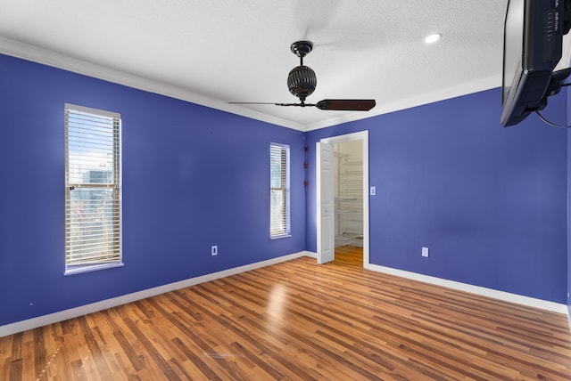 unfurnished bedroom featuring ceiling fan, ornamental molding, hardwood / wood-style floors, and a textured ceiling