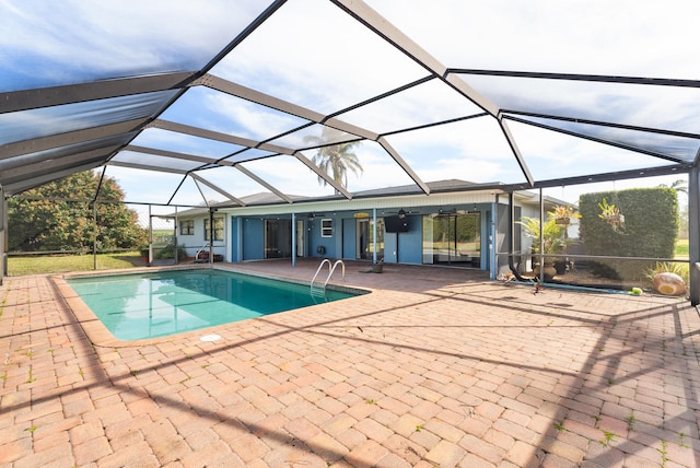 view of swimming pool featuring ceiling fan, a patio area, and glass enclosure