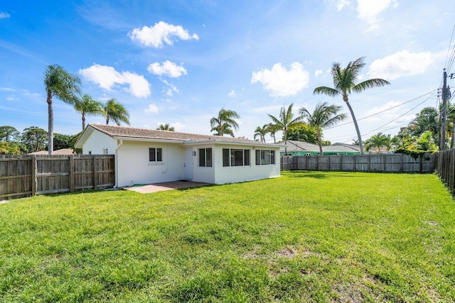 back of house with a patio area and a lawn