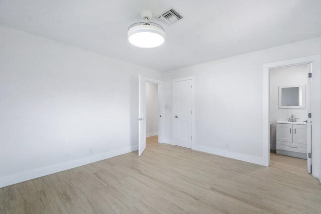 unfurnished bedroom featuring sink and light hardwood / wood-style flooring