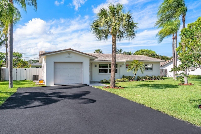 ranch-style home featuring a garage, central AC unit, and a front lawn