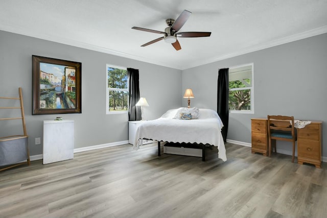 bedroom featuring ornamental molding, ceiling fan, and light hardwood / wood-style flooring