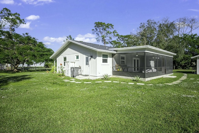 back of house with a sunroom and a yard