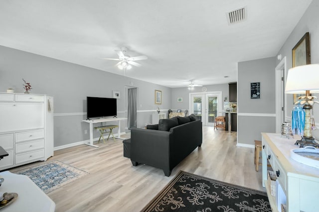 living room featuring ceiling fan, light hardwood / wood-style floors, and french doors