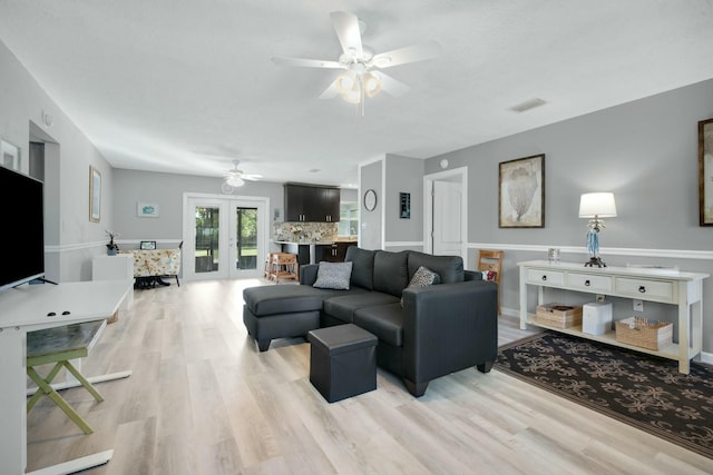 living room with french doors, ceiling fan, and light hardwood / wood-style floors