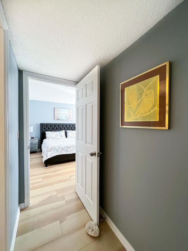 hallway featuring wood-type flooring and a textured ceiling