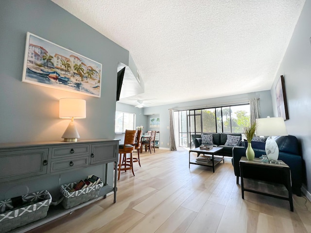 living room with a textured ceiling and light wood-type flooring