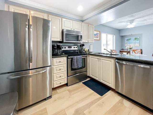 kitchen with sink, crown molding, light hardwood / wood-style flooring, ceiling fan, and stainless steel appliances