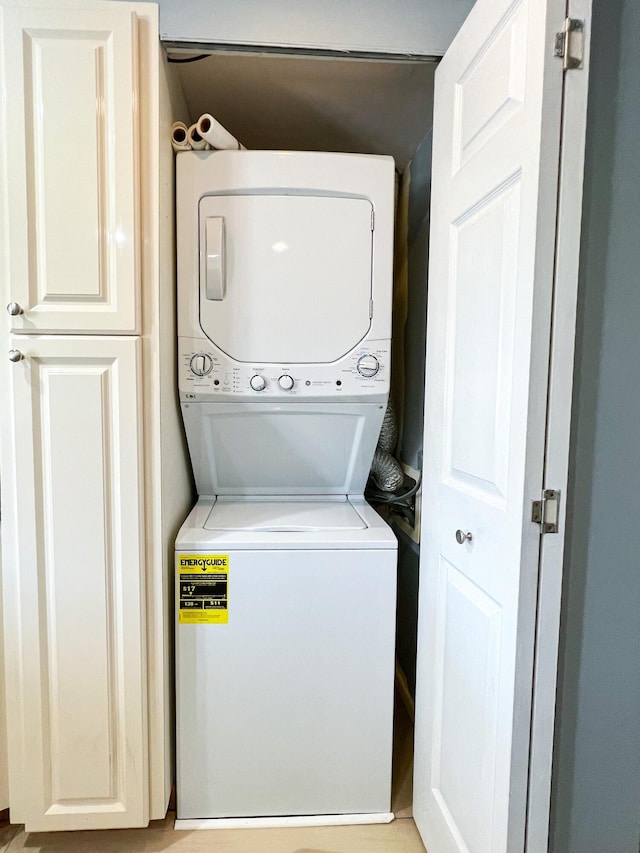 washroom featuring stacked washer and clothes dryer