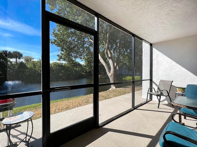 sunroom / solarium featuring a water view