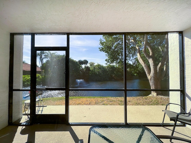 unfurnished sunroom featuring a water view