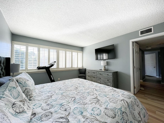 bedroom featuring wood-type flooring and a textured ceiling