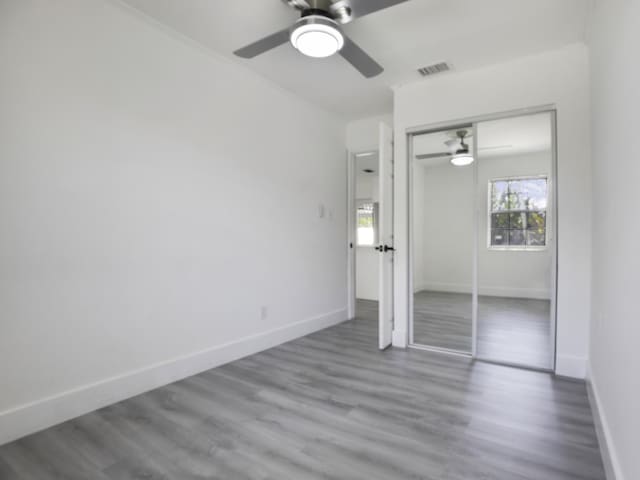 unfurnished bedroom with hardwood / wood-style floors, a closet, and ceiling fan