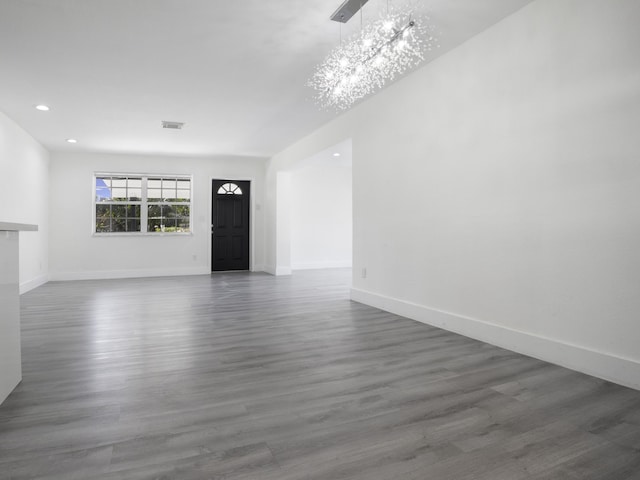 unfurnished living room featuring dark hardwood / wood-style floors and a chandelier