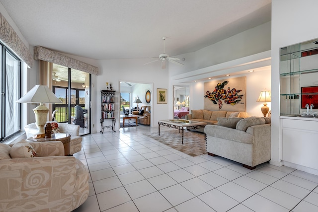 tiled living room featuring ceiling fan, lofted ceiling, and sink