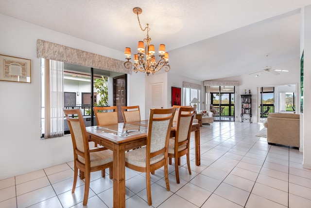 dining room with lofted ceiling, ceiling fan with notable chandelier, a textured ceiling, and light tile patterned floors