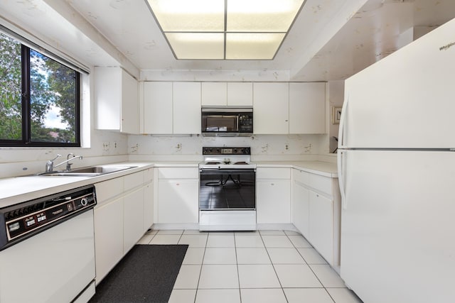 kitchen featuring sink, light tile patterned floors, white cabinets, and white appliances