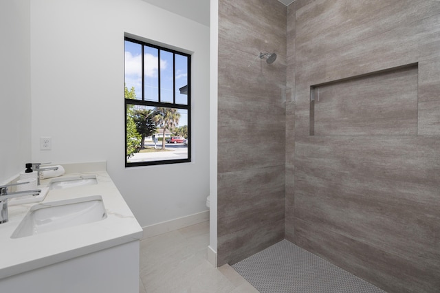 bathroom with vanity, toilet, tile patterned flooring, and a tile shower