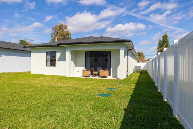 rear view of house with a patio and a lawn