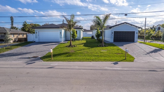 single story home featuring a garage and a front lawn