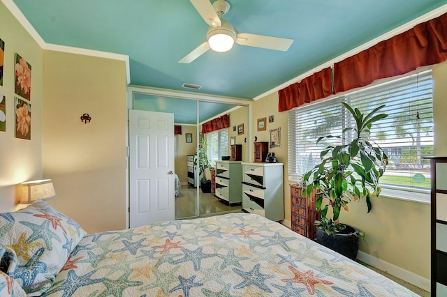 bedroom featuring ornamental molding, ceiling fan, and a closet