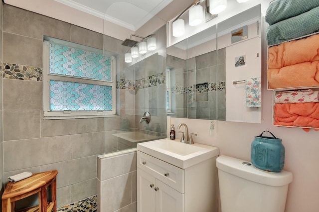 bathroom featuring vanity, crown molding, toilet, and tiled shower