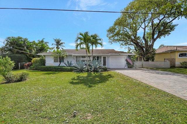 ranch-style house with a garage and a front lawn