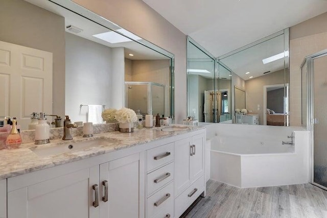 bathroom featuring lofted ceiling, independent shower and bath, wood-type flooring, and vanity