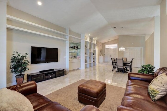 living room with vaulted ceiling, a notable chandelier, and built in features