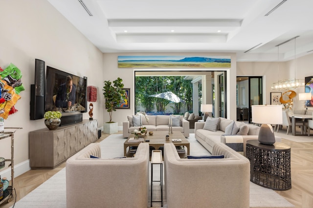 living room featuring light parquet flooring and a tray ceiling