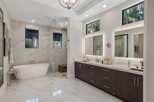 bathroom featuring a notable chandelier, shower with separate bathtub, and vanity