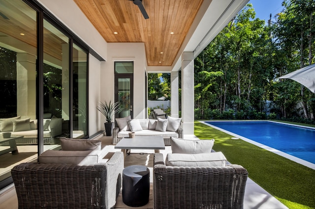 view of swimming pool with a patio, outdoor lounge area, and ceiling fan