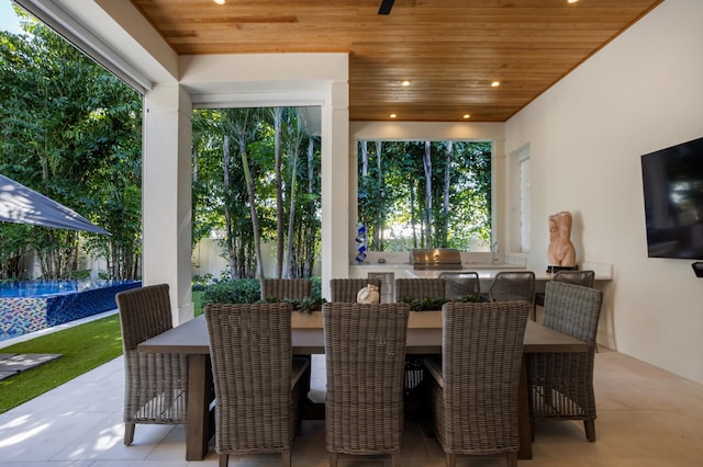 dining area with a wealth of natural light and wood ceiling