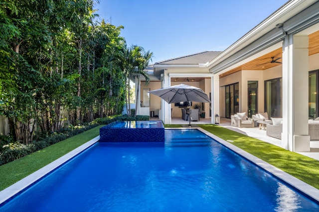 view of pool with a lawn, ceiling fan, a patio area, an outdoor hangout area, and an in ground hot tub