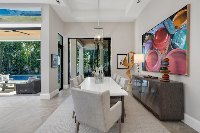 dining room with ceiling fan with notable chandelier and light parquet floors