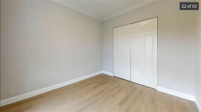 unfurnished bedroom featuring crown molding, wood-type flooring, and a closet