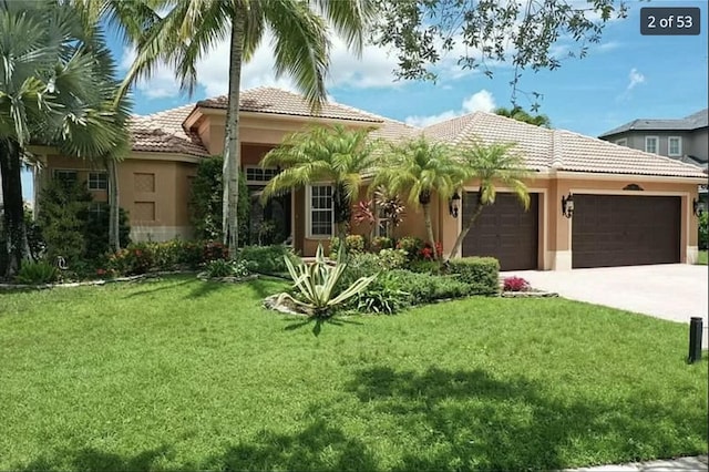 mediterranean / spanish-style house with a garage and a front yard