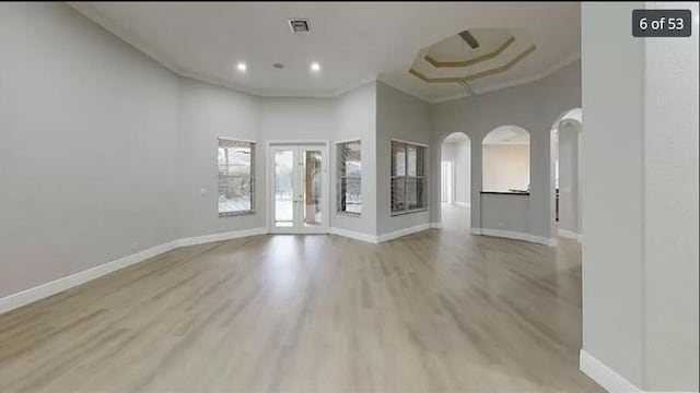 interior space featuring crown molding, light hardwood / wood-style floors, and a high ceiling