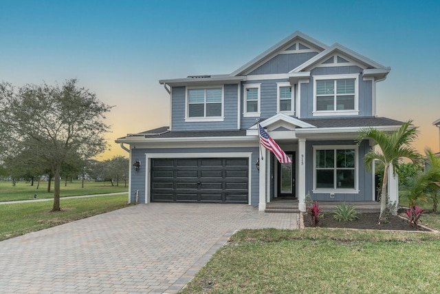 view of front of home with a garage and a lawn