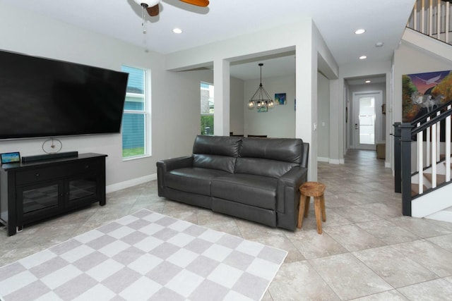 living room featuring ceiling fan with notable chandelier