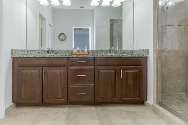 bathroom featuring a shower with door, vanity, and tile patterned flooring