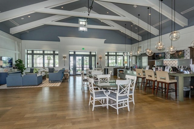 dining area featuring hardwood / wood-style floors, beam ceiling, high vaulted ceiling, and french doors