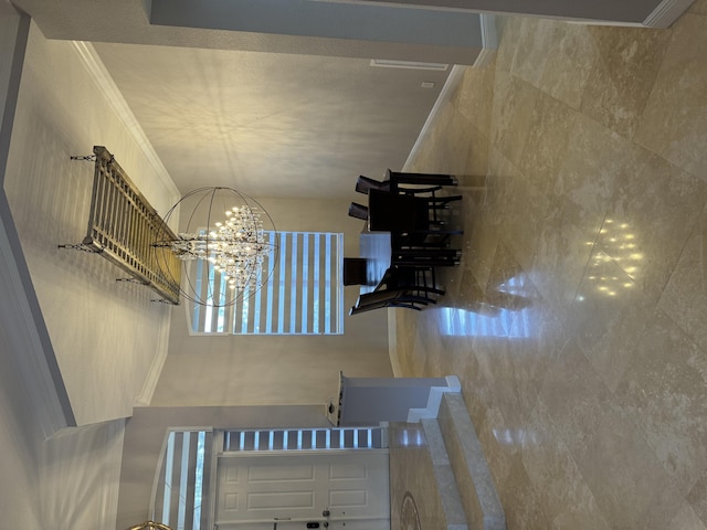 staircase with an inviting chandelier and crown molding