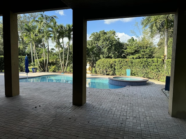 view of swimming pool featuring an in ground hot tub and a patio area