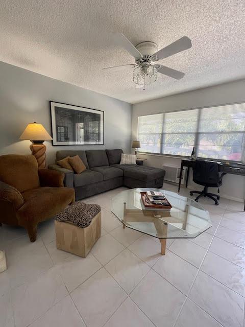 living room with plenty of natural light, a textured ceiling, and ceiling fan