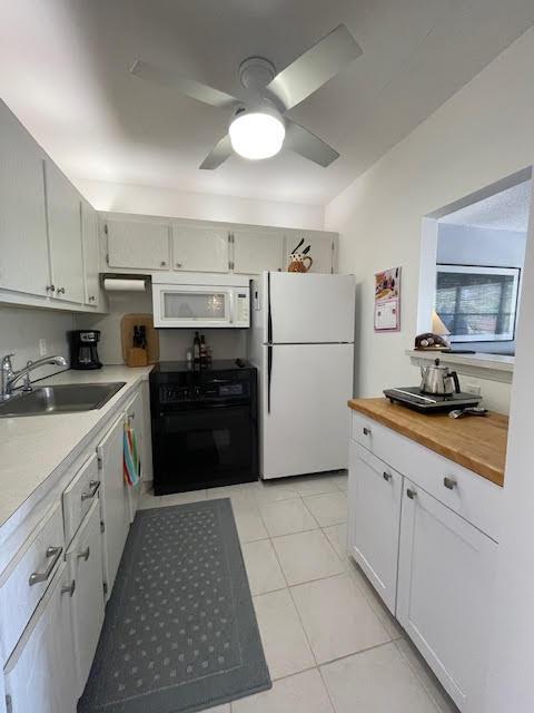 kitchen with sink, white cabinets, light tile patterned floors, ceiling fan, and white appliances